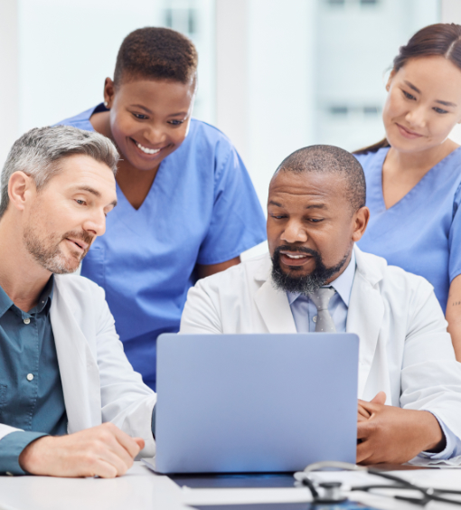 Happy diverse healthcare team discusses things in front of a laptop